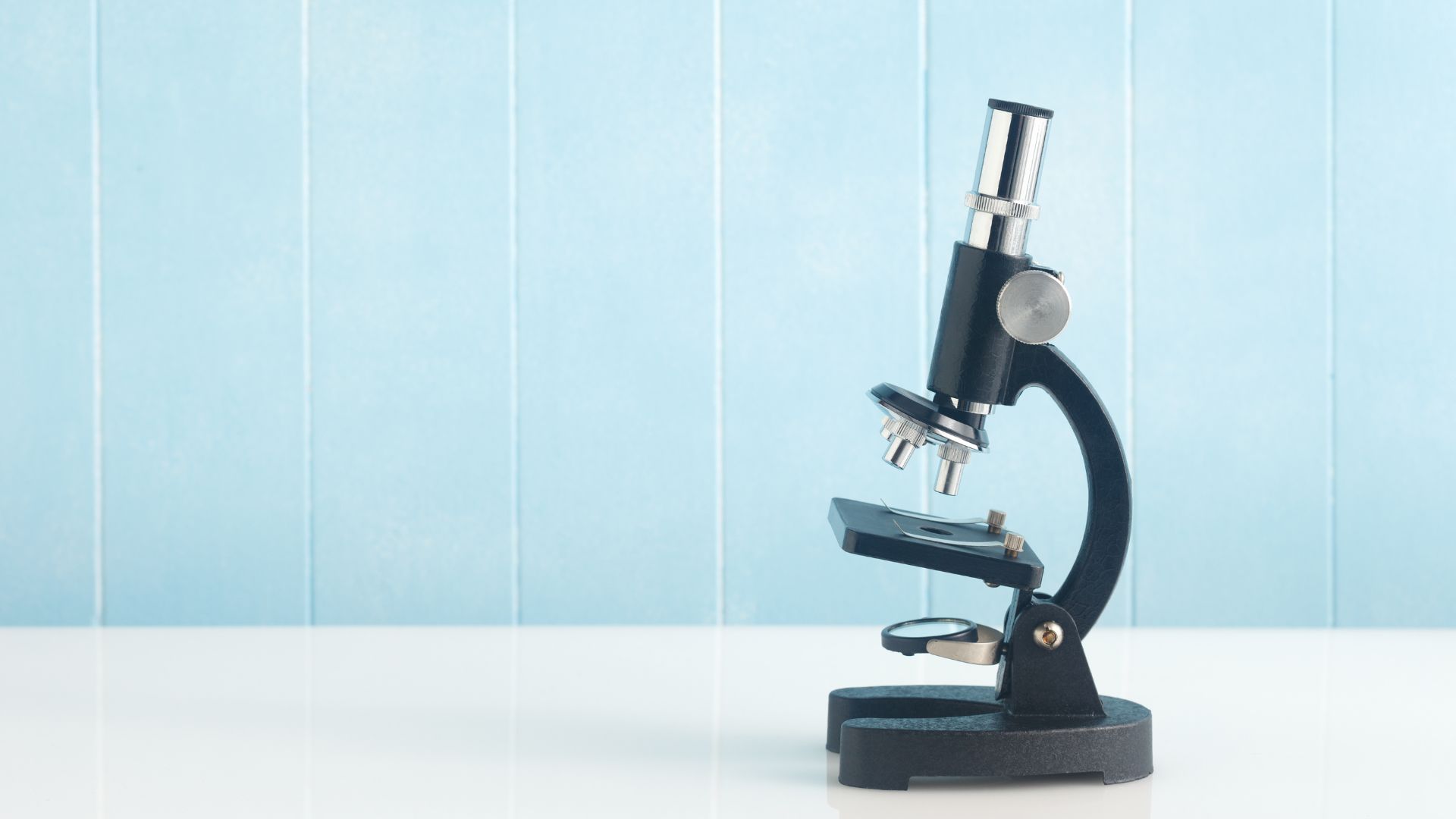 Picture of a microscope against a blue backdrop.