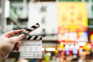 Assistant director holding a film slate on Yaowarat Road, which is Thailand's Chinatown and is popular for filming concept films about the film industry and shooting content on social media.; Shutterstock ID 2500841447; purchase_order: -; job: -; client: -; other: -