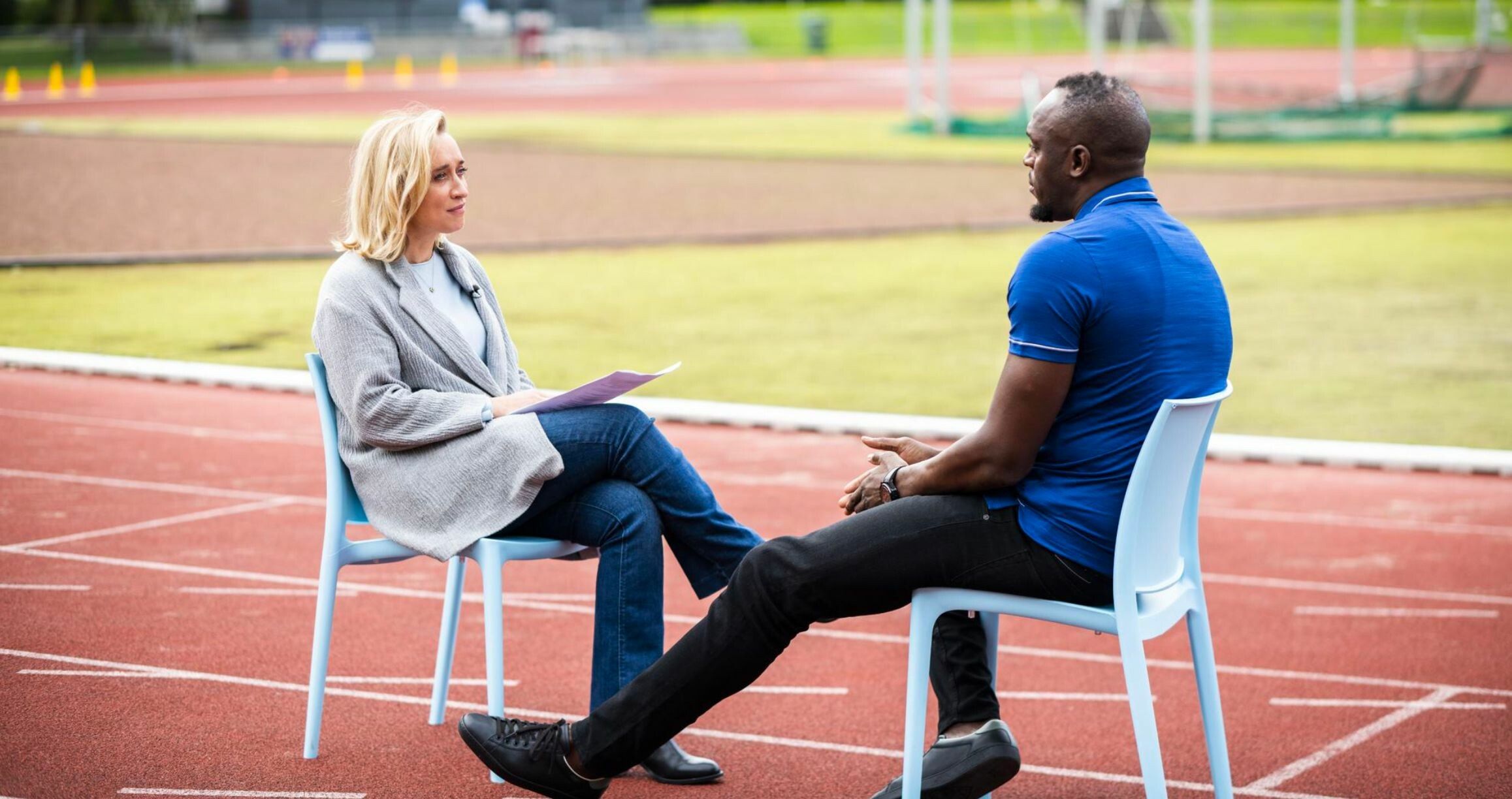 Eva Jinek met Usain Bolt op atletiek baan.