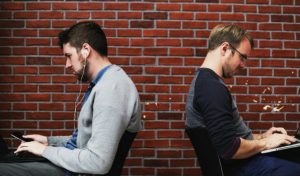 two men working laptops