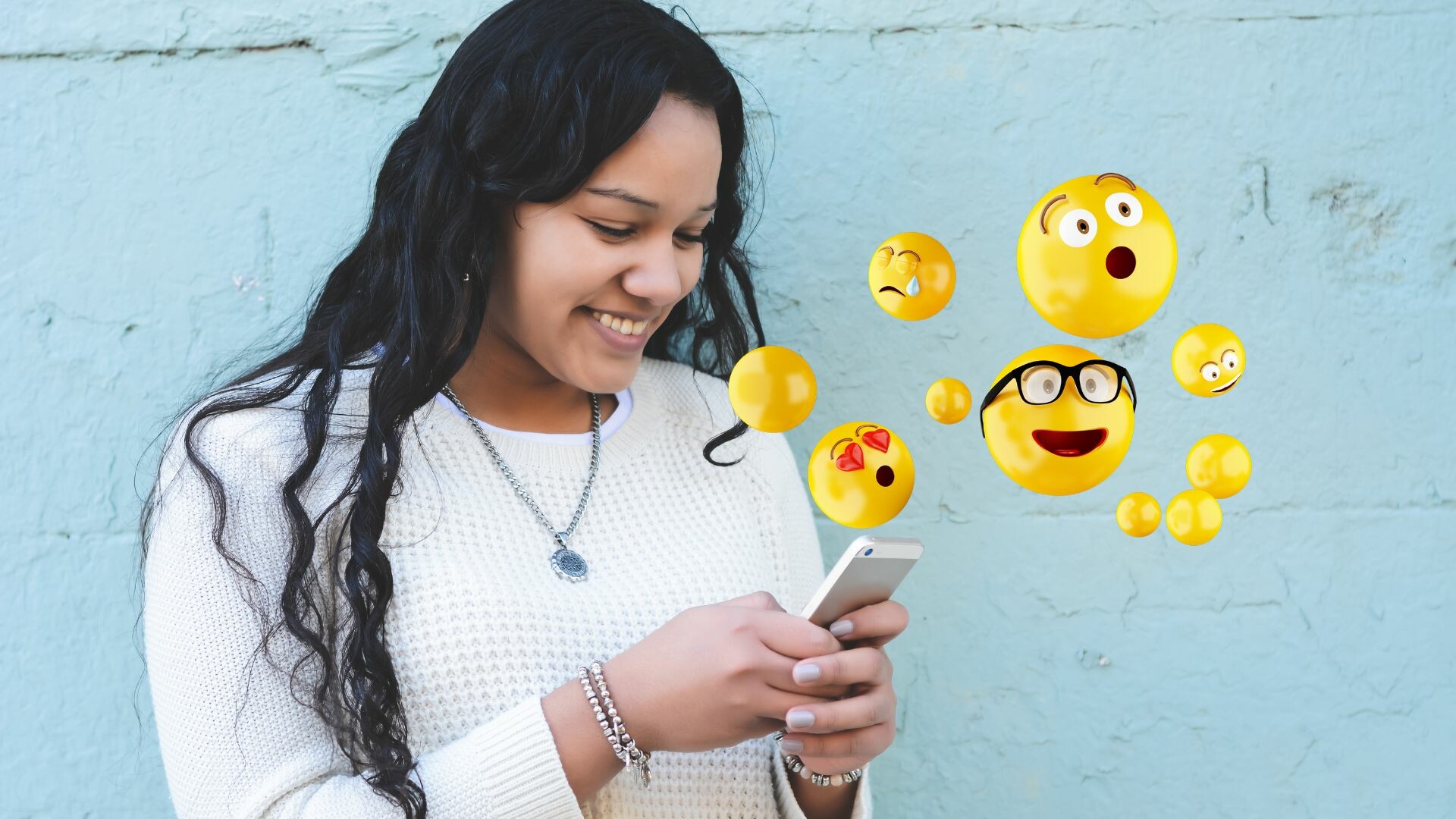 Girl with long black hair texting with 3D render of emojis for TEAM LEWIS's A Week in Review