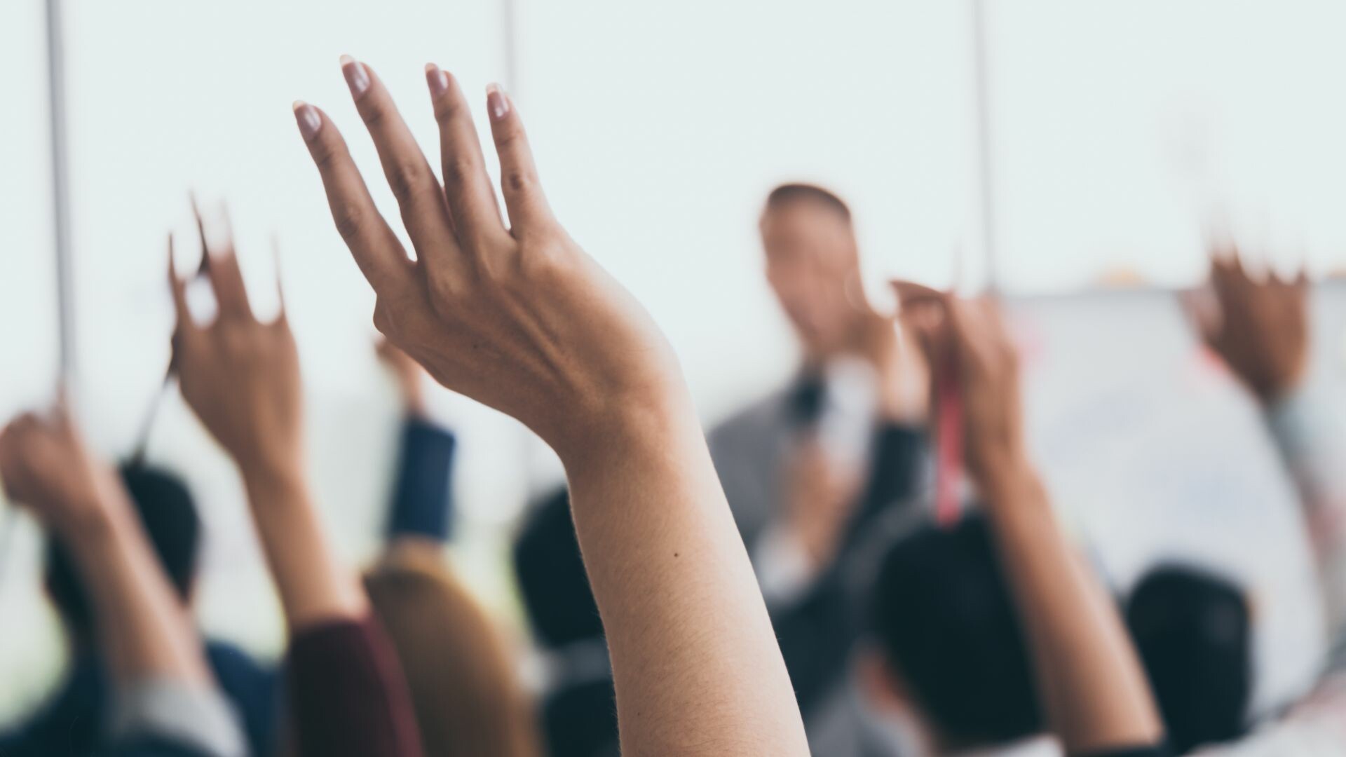 Hands raised in a classroom.