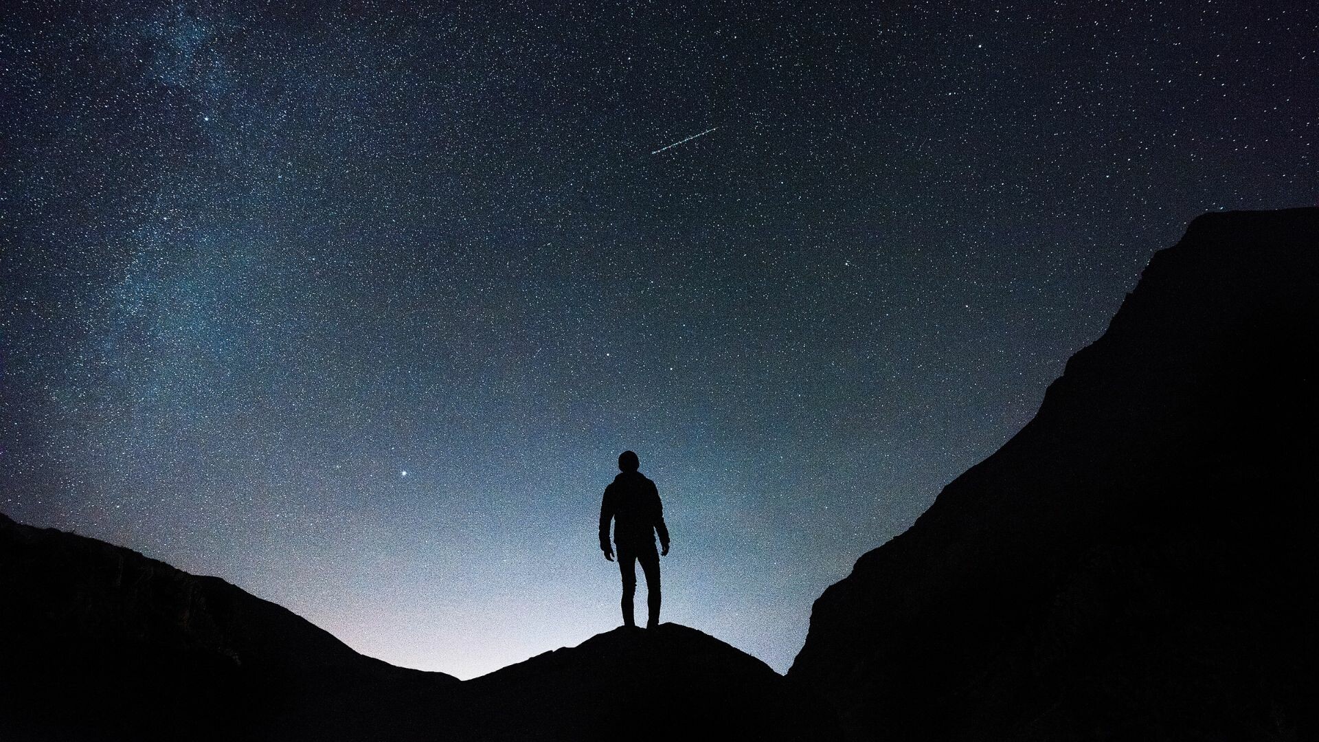 Person looking up at the night sky filled with stars.