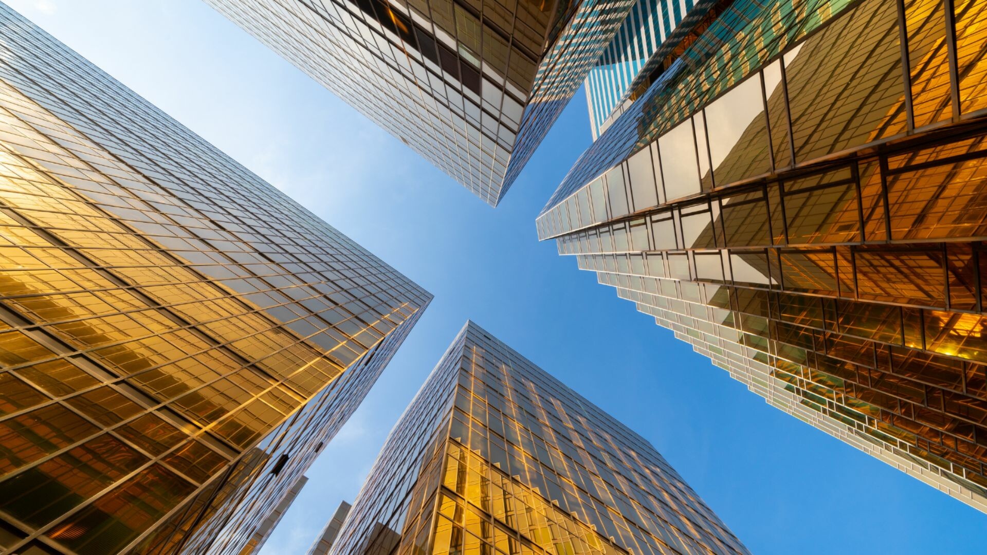 Upward facing picture of tall glass buildings.