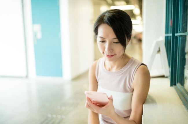 woman checking her phone in an office setting