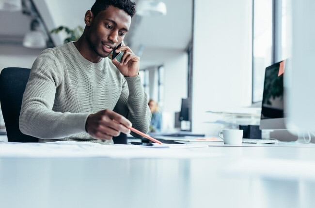 man working at his desk on the phone