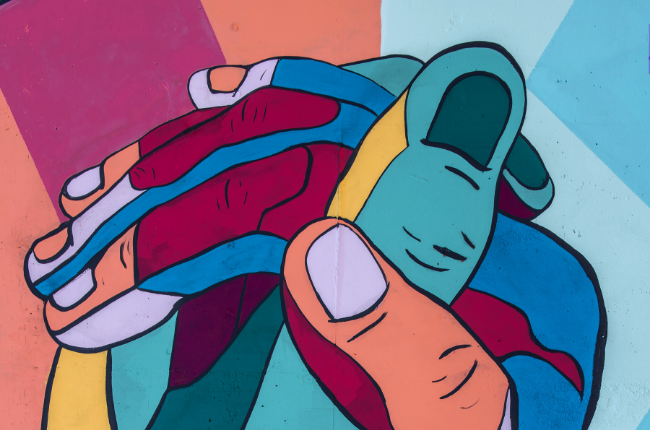 Color-block mural of two hands holding each other
