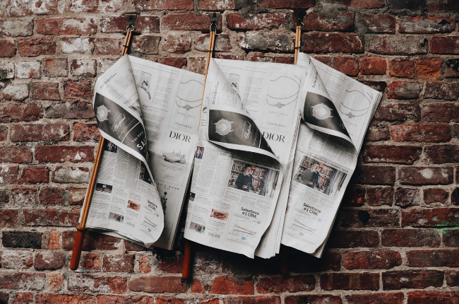 Newspapers on brick wall