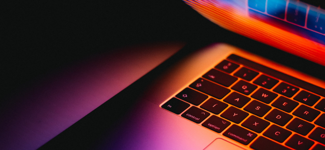 Orange and purple lit laptop screen and keyboard
