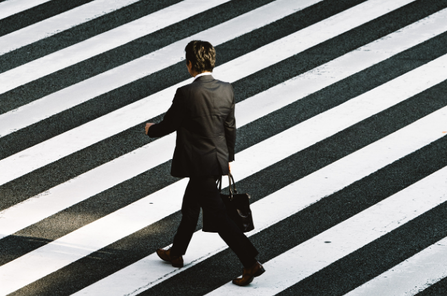 Person in suit walking through a crosswalk