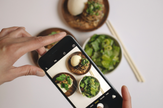 Person taking photo of bowls with iPhone