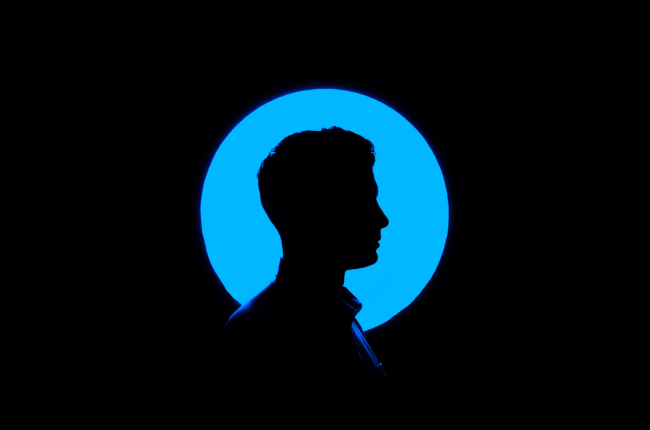 Silhouette of person against blue neon circle