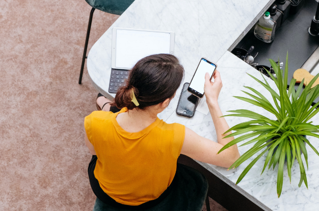 Person at desk with phone and laptop