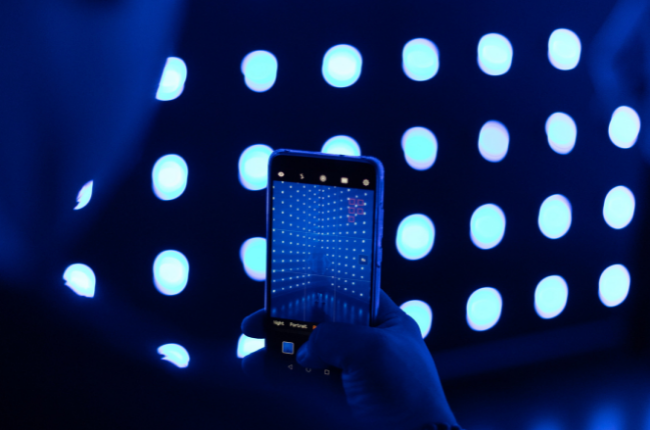 Person taking photo of blue lights on mobile phone