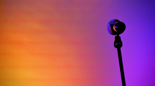 Mic stand against orange and purple gradient lights