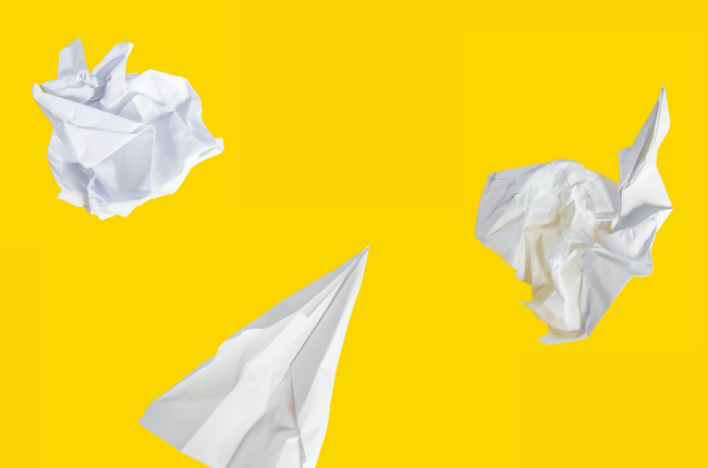 Crumpled pieces of paper on yellow background