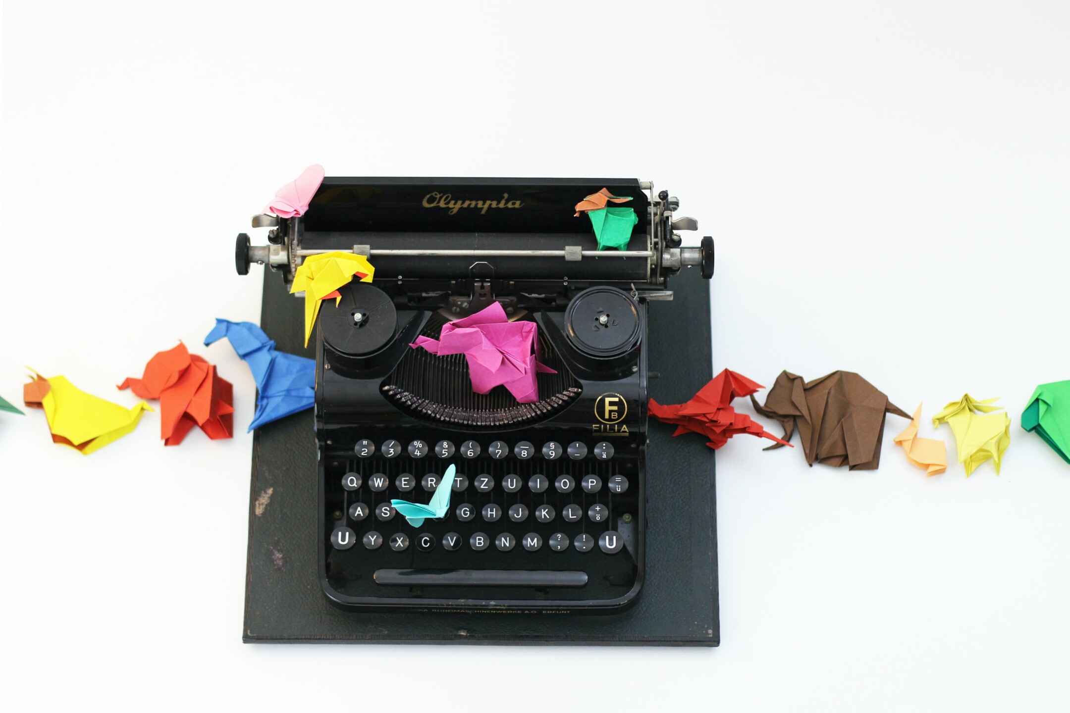 black typewriter with colorful origami animals