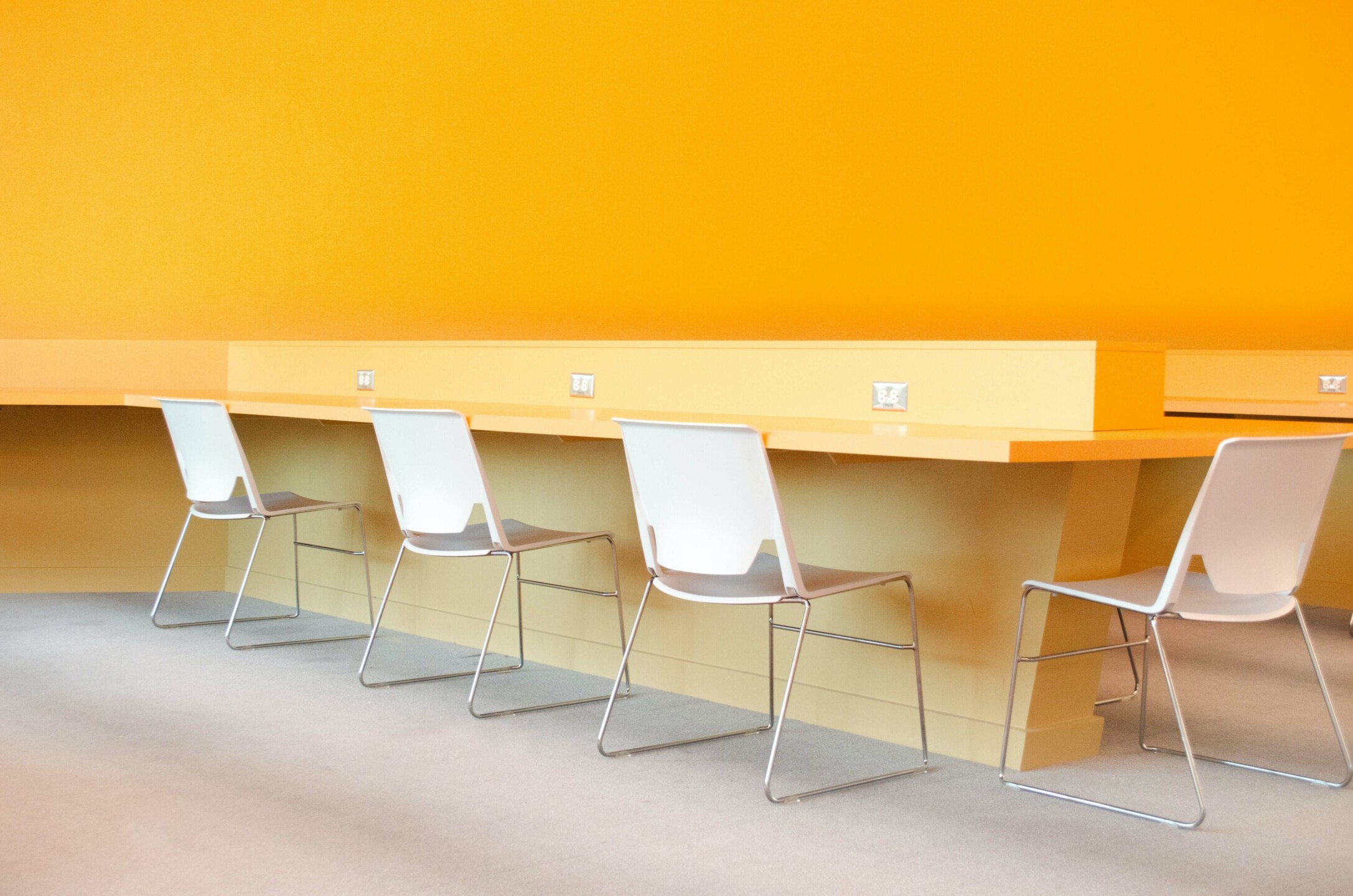 four white chairs at a table in a yellow room